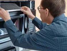 Appliance repair technician replacing a microwave vent filter in Fort Worth, TX